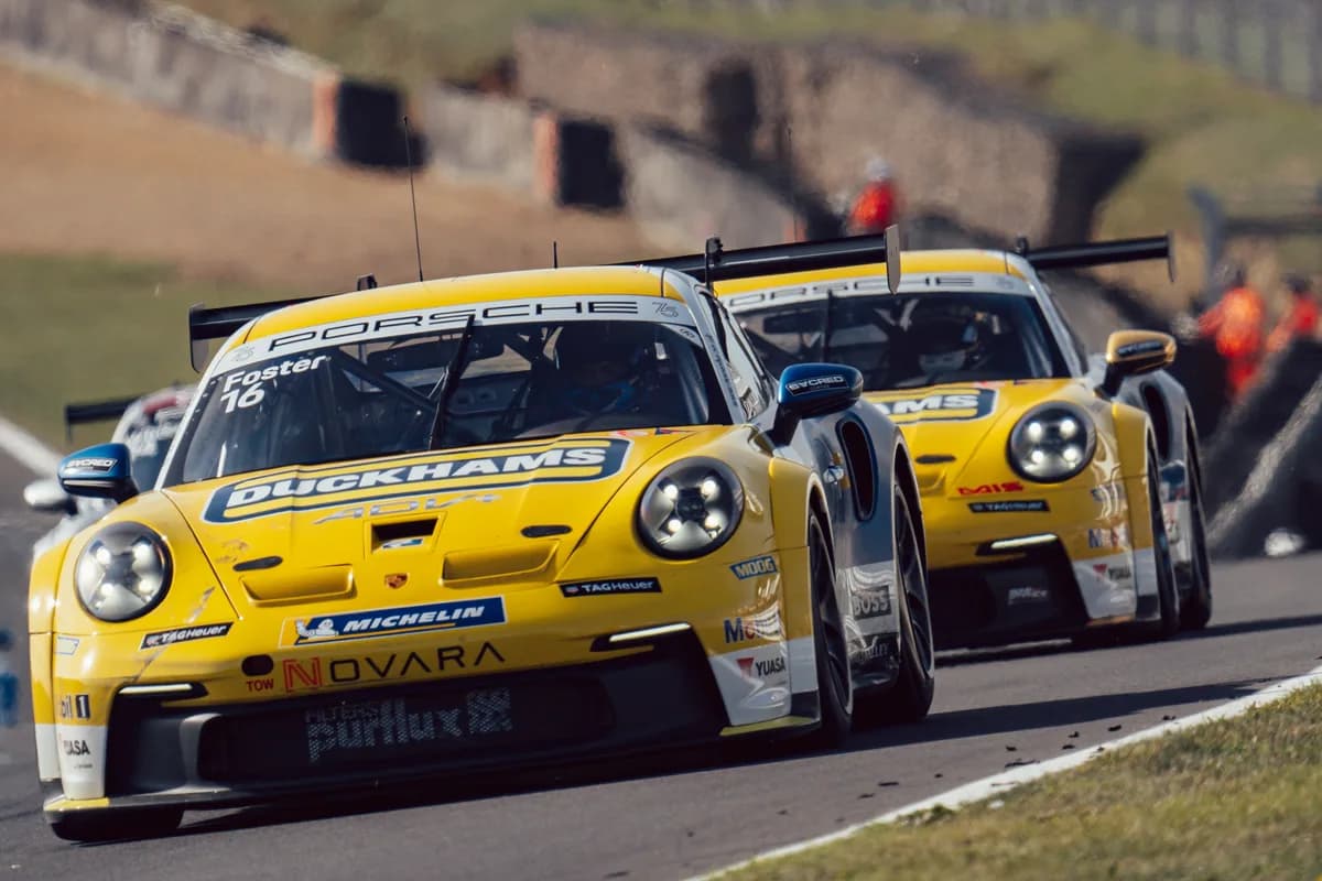 Adam Smalley's yellow and blue Duckhams Porsche 911 leading a pack through a corner.