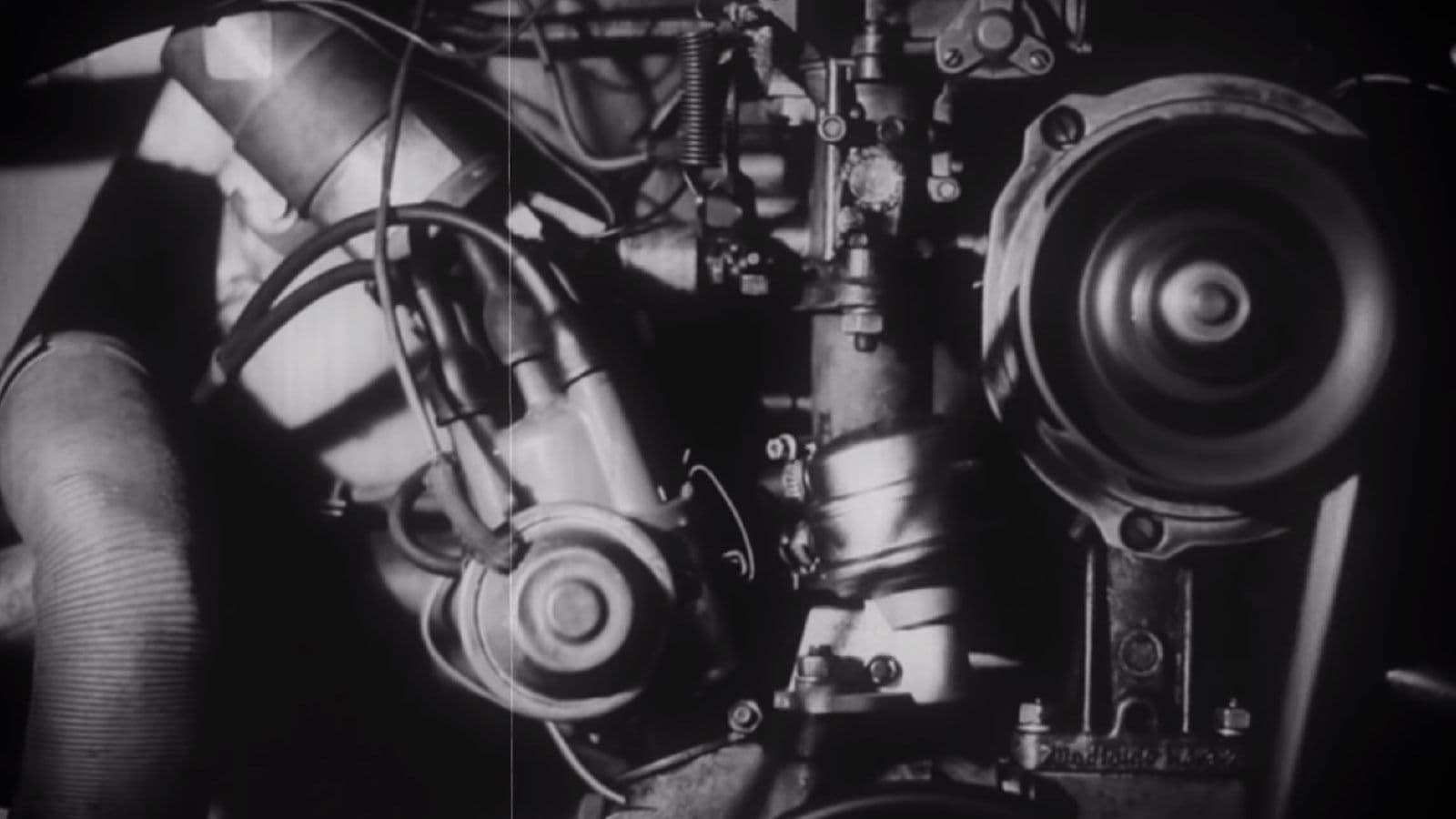 Black and white close-up of an engine's timing gear and cylinder head.